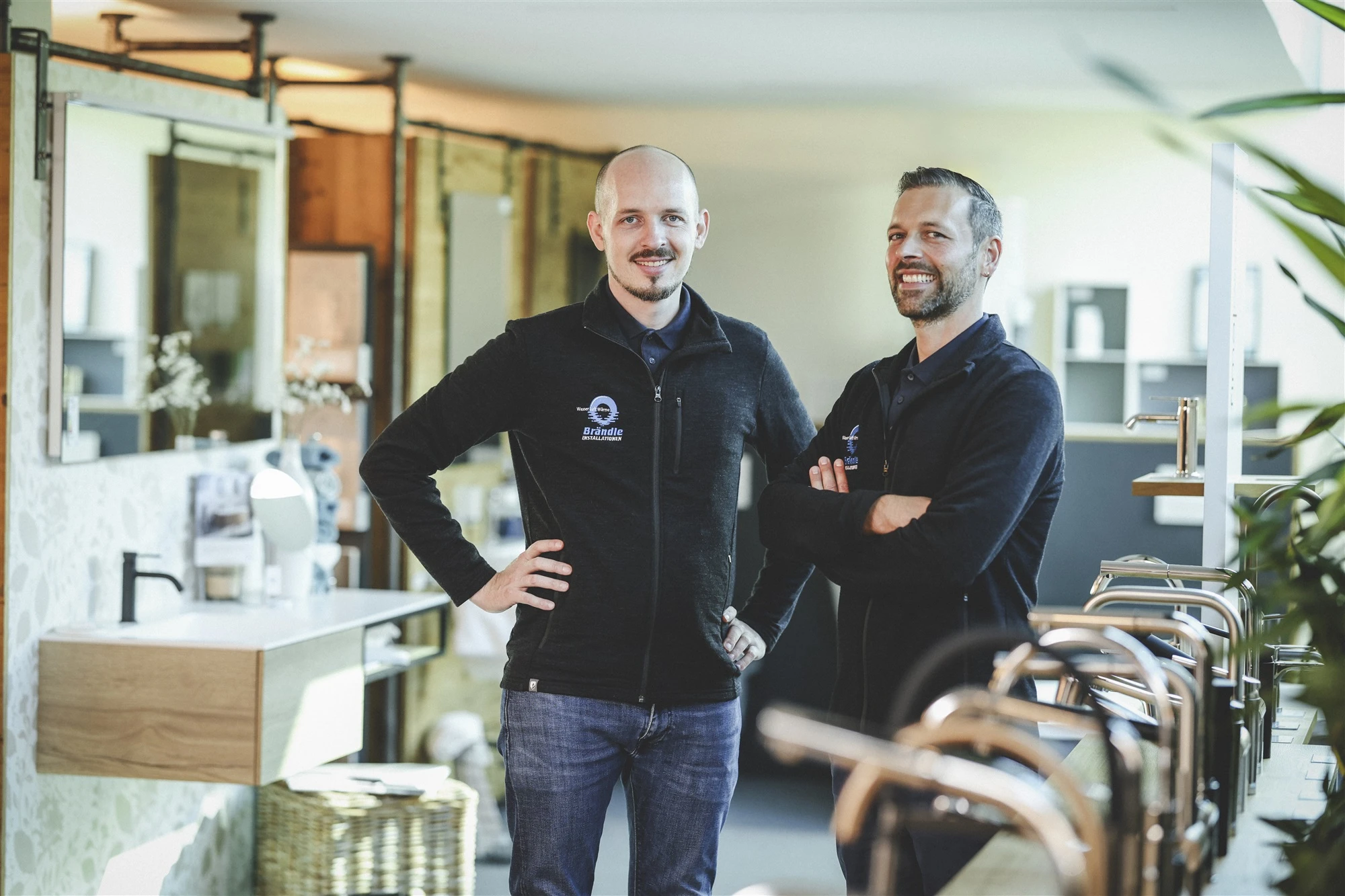Die Berater Thomas und Daniel lachen in der Brändle-Ausstellung in Koblach