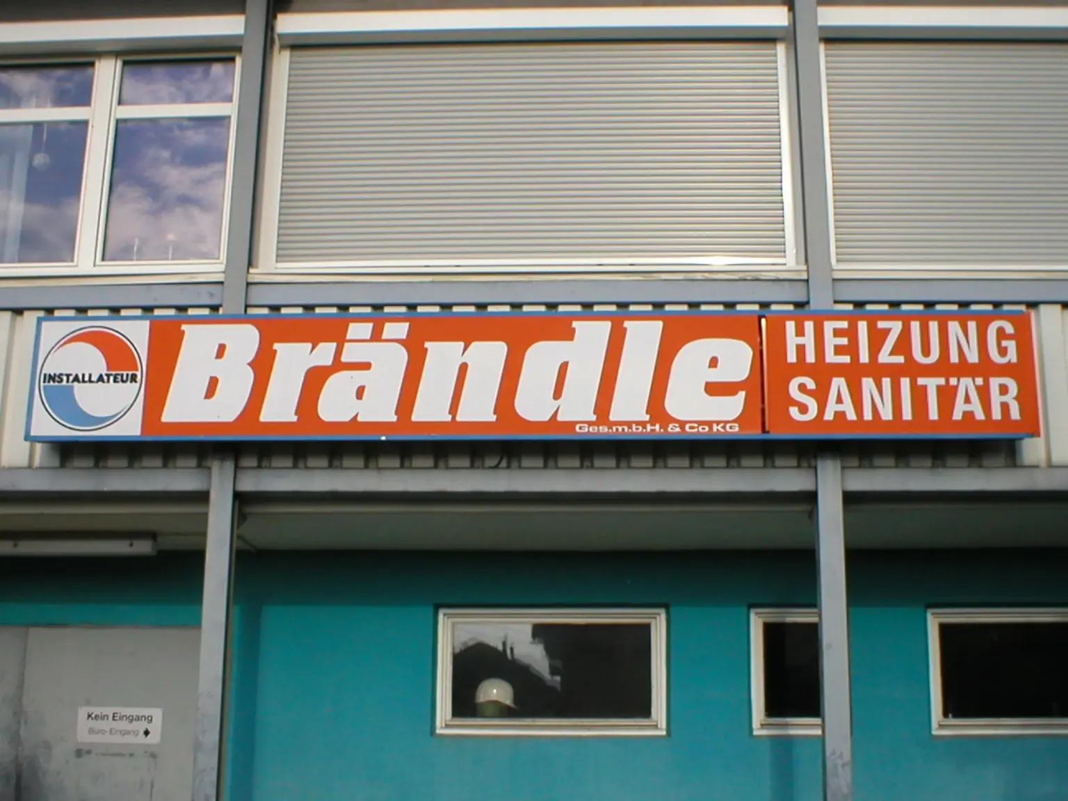 Das aufgestockte Betriebsgebäude in Altach mit dem orangen Brändle-Schild und türkiser Wand