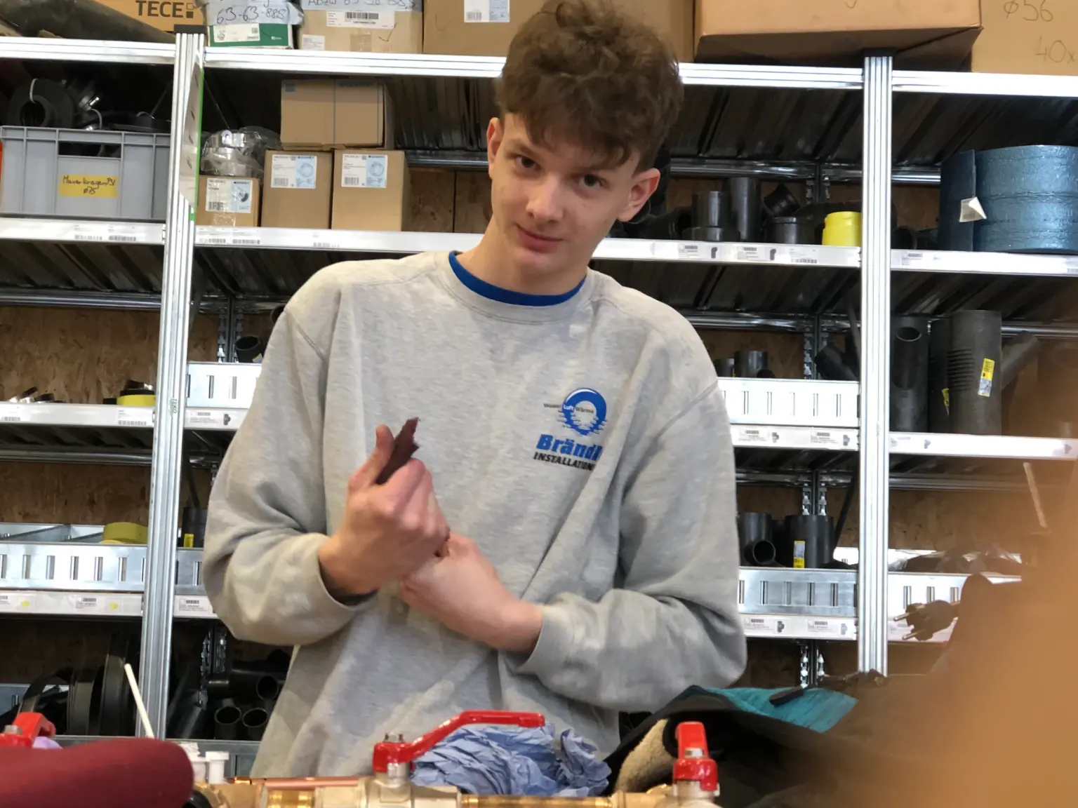Lehrling erklärt in der internen Lehrlingsausbildung ein Werkstück
