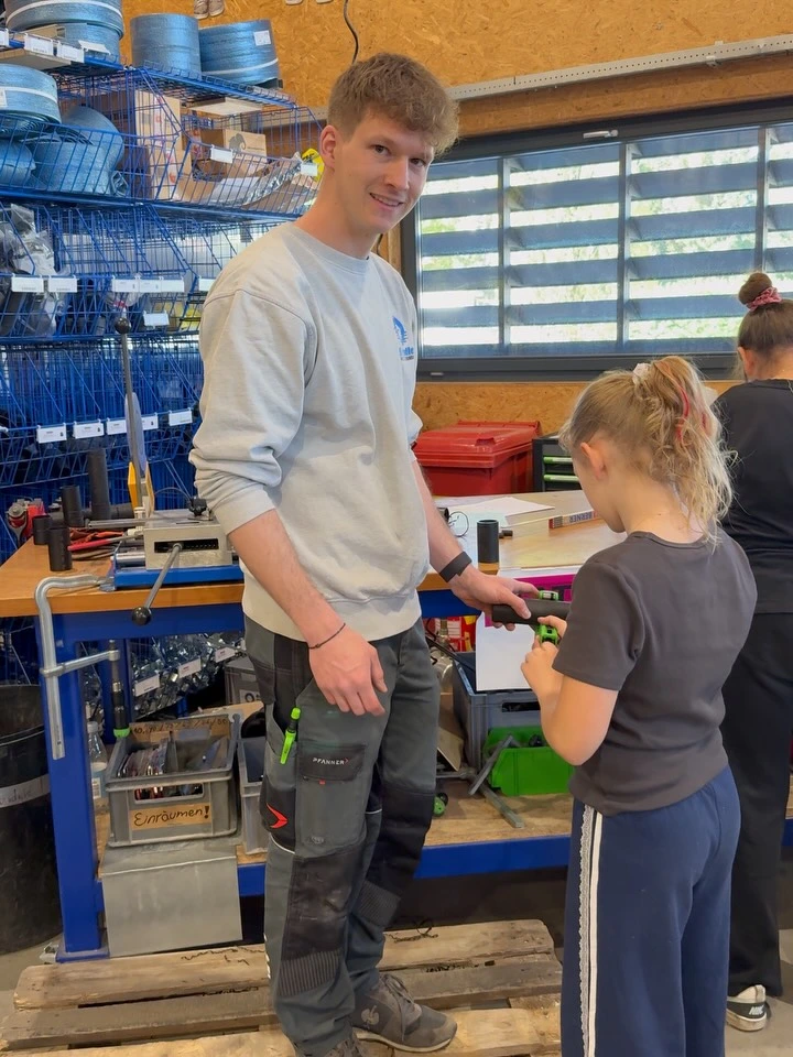Lehrling erklärt einer Schülerin ein Werkstück in der Brändle-Werkstatt